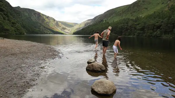 Badende Besucher am Upper Lake von Glendalough