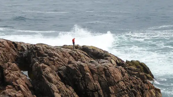 Mann auf Klippen am Fanad Head Lighthouse