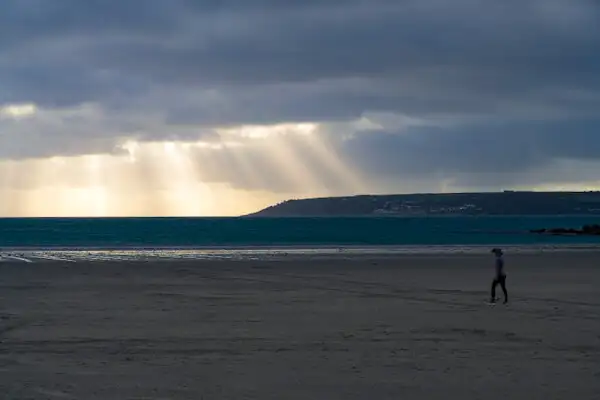 Dramatisches Licht am Strand mit Penzance im Hintergrund (Cornwall)