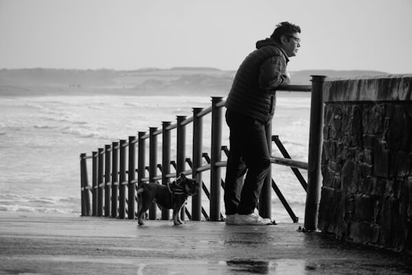 Mann mit Hund am Meer